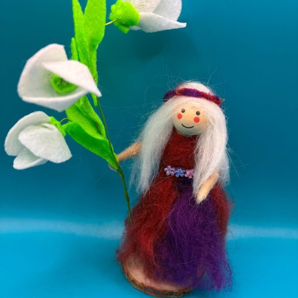 Fairy holding white flowers on wood slice