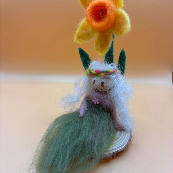 Fairy with daffodil on wood slice