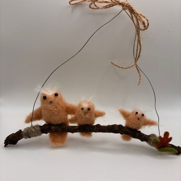 Family of owls on hanging twig