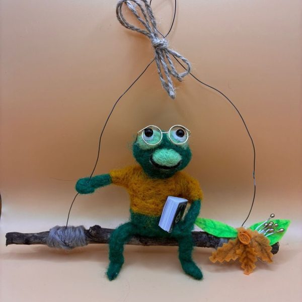 Frog with glasses and book on hanging twig