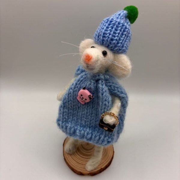 Mouse in blue knitted dress and hat on wood slice