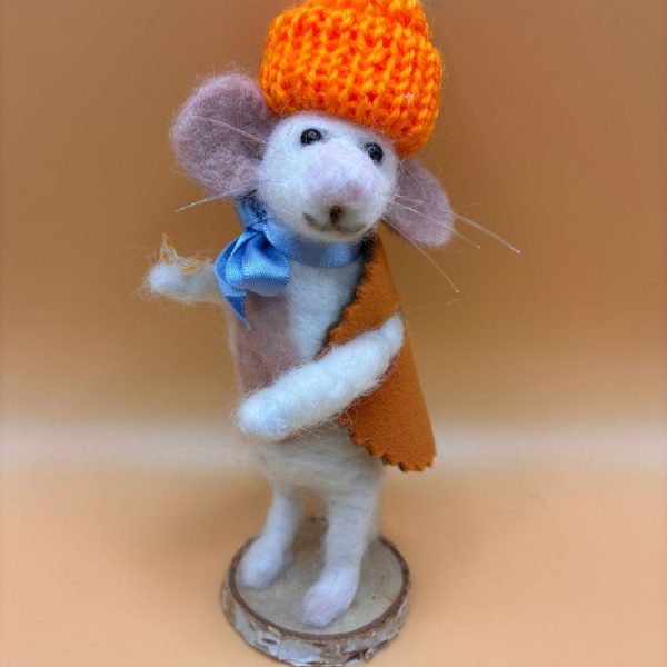 Mouse in orange knitted hat and cape on wood slice