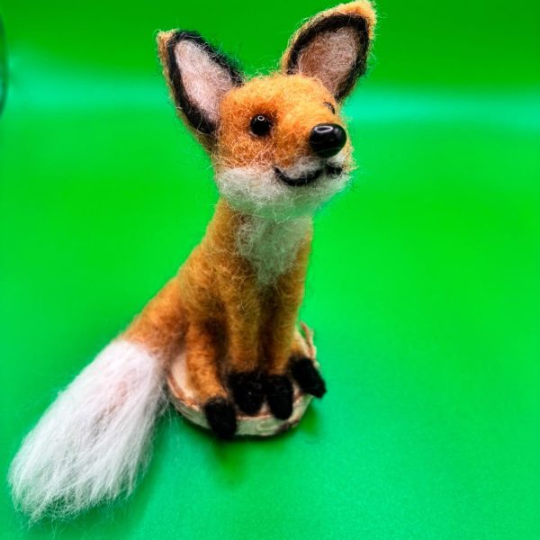 Smiling fox on a wood slice