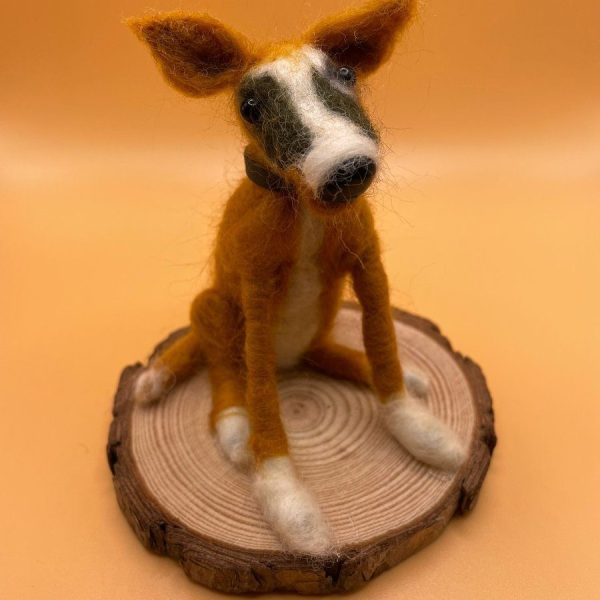Tan and white dog on wood slice